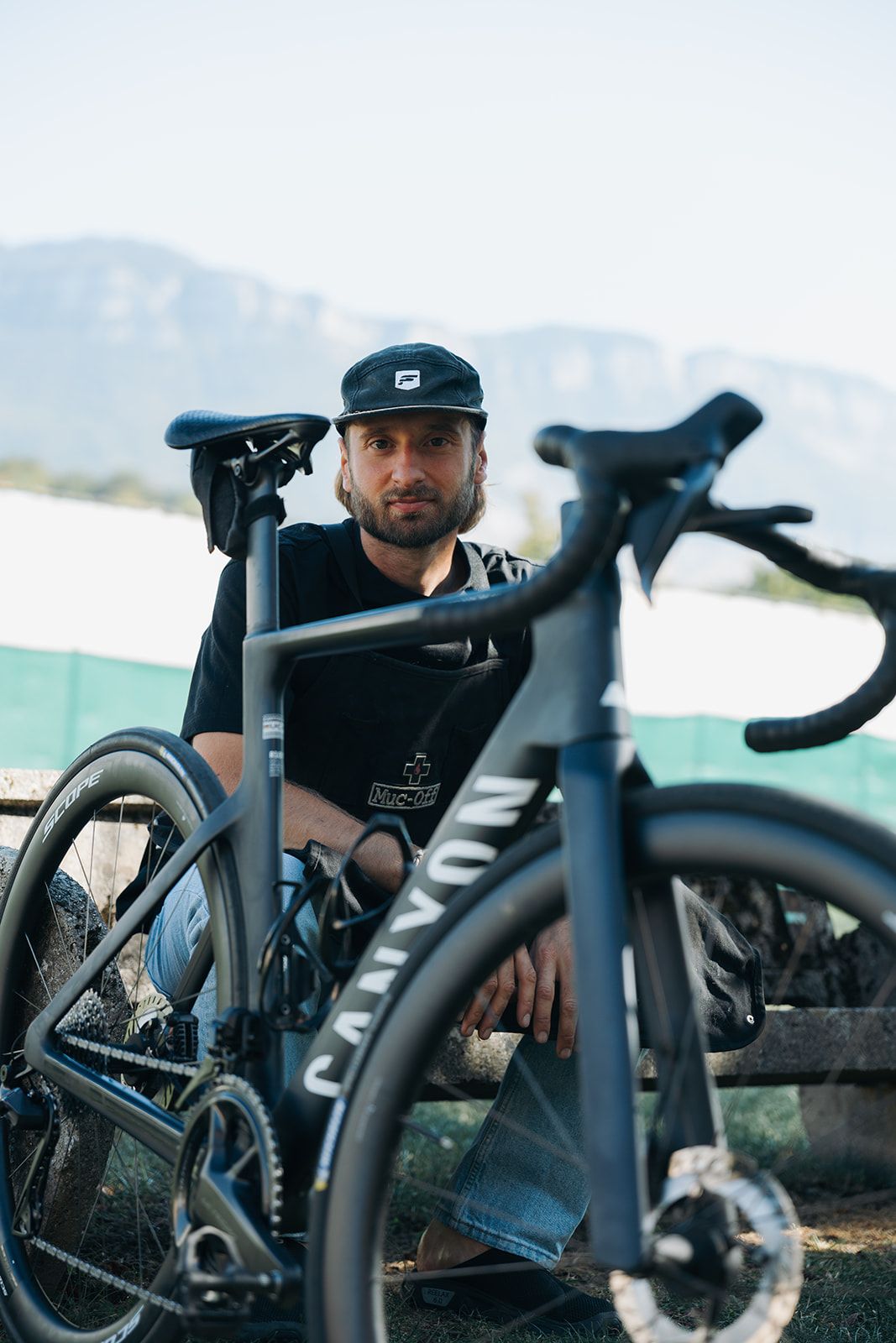 Alexis et un vélo de route Canyon préparé à l'atelier, montagnes de Savoie en arrière-plan
