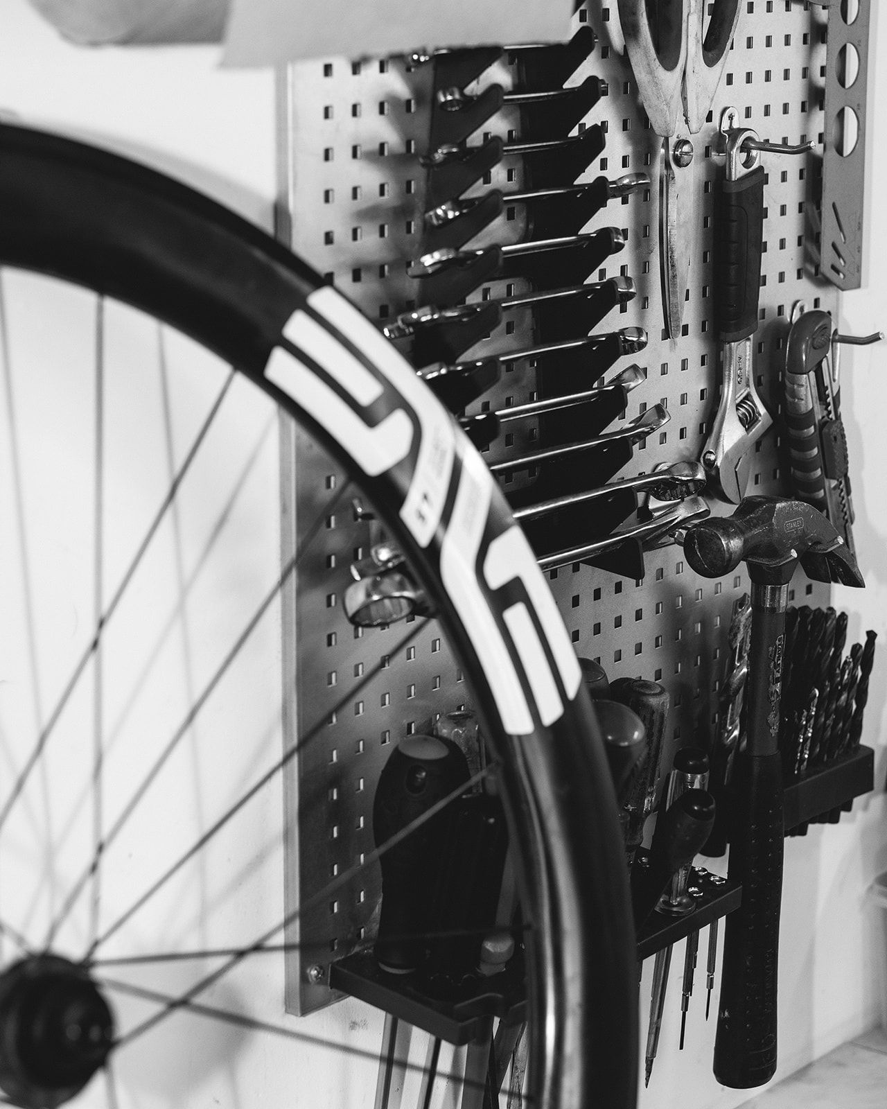 Roue carbone Enve devant le panneau d'outils de l'atelier de réparation vélo en Savoie